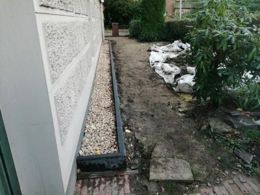 Sockel mit Kiesstreifen absichern.